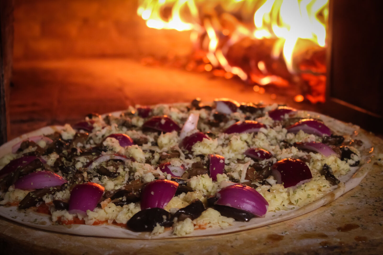 Pizza saindo do forno a lenha